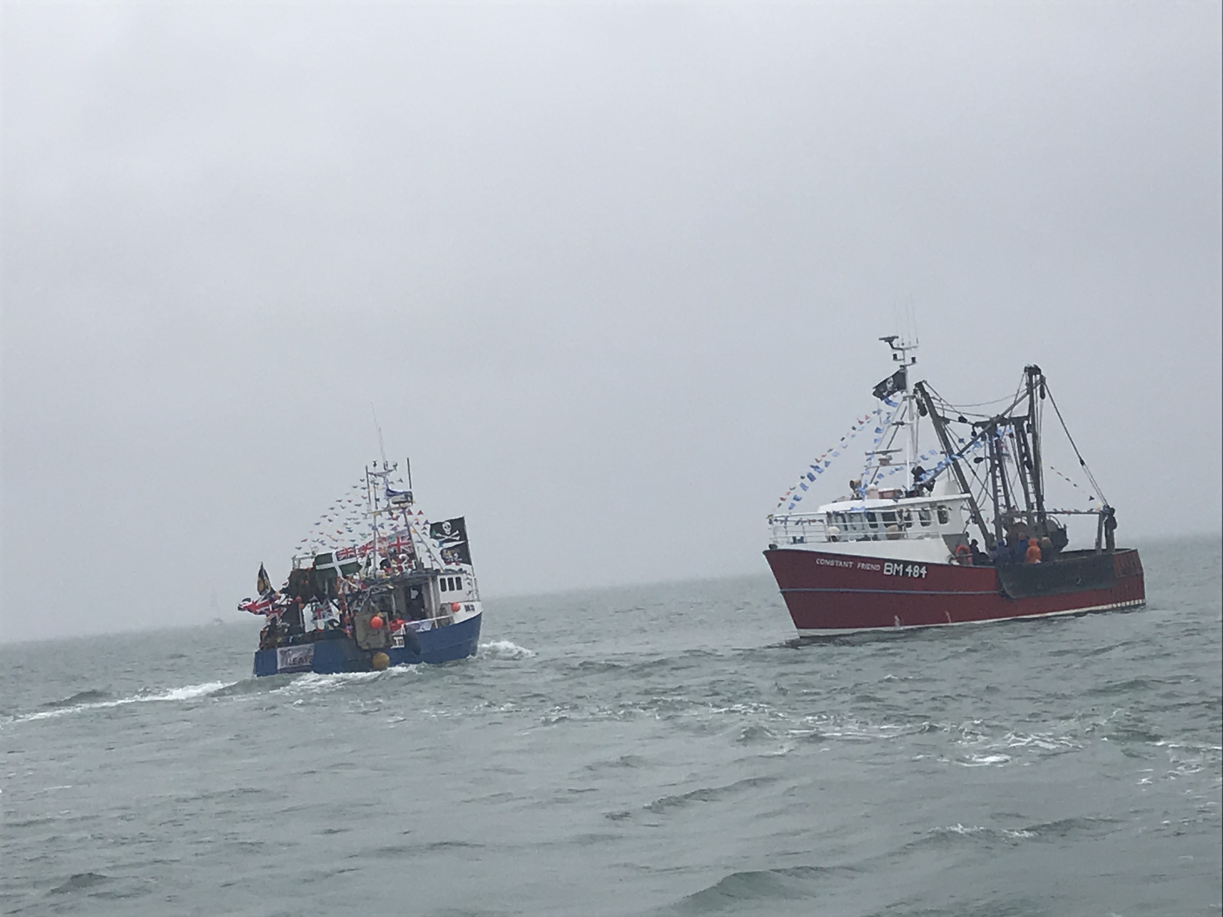 Two trawlers at sea in grey weather