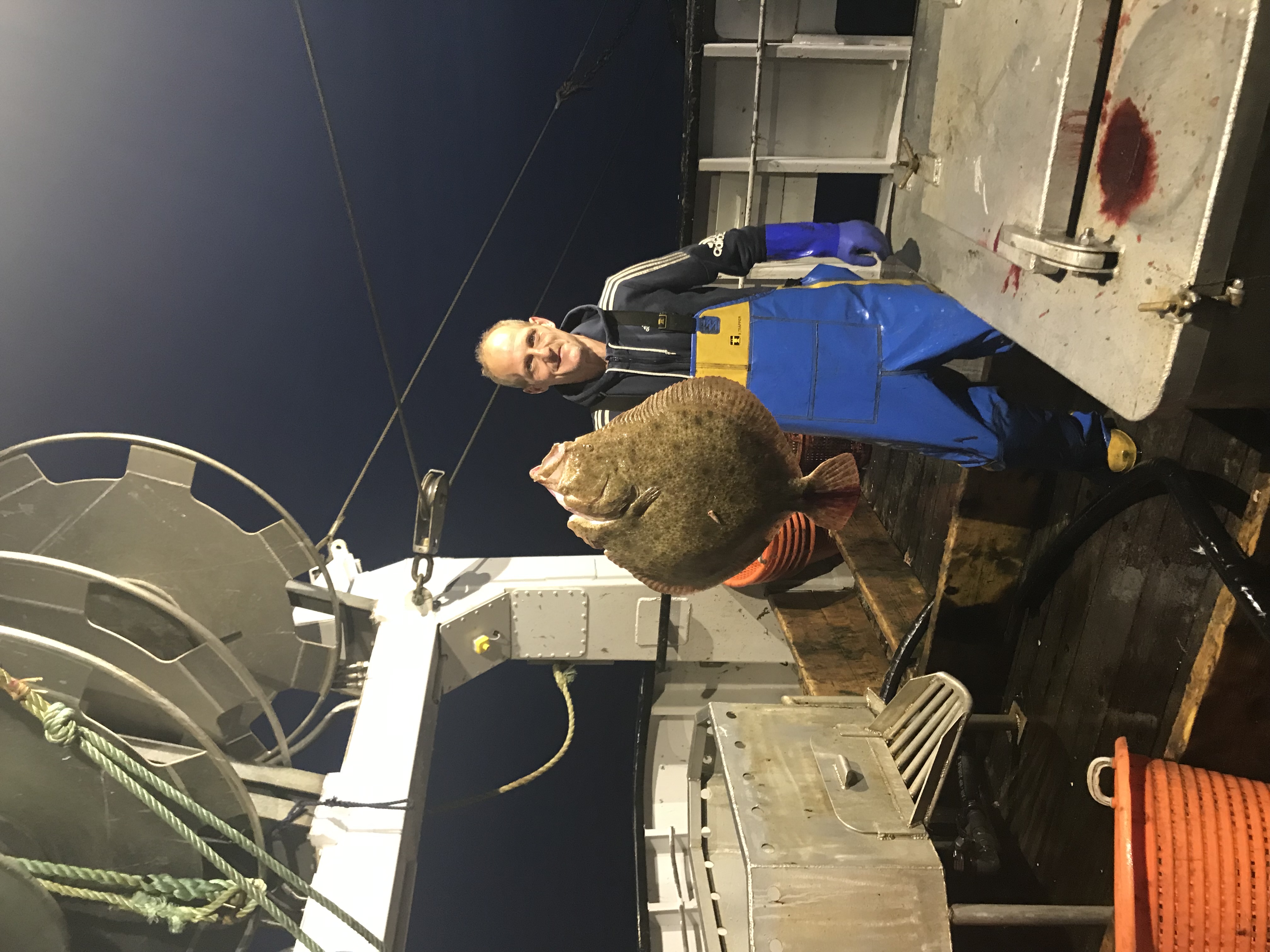 Crew holding large turbot — night haul