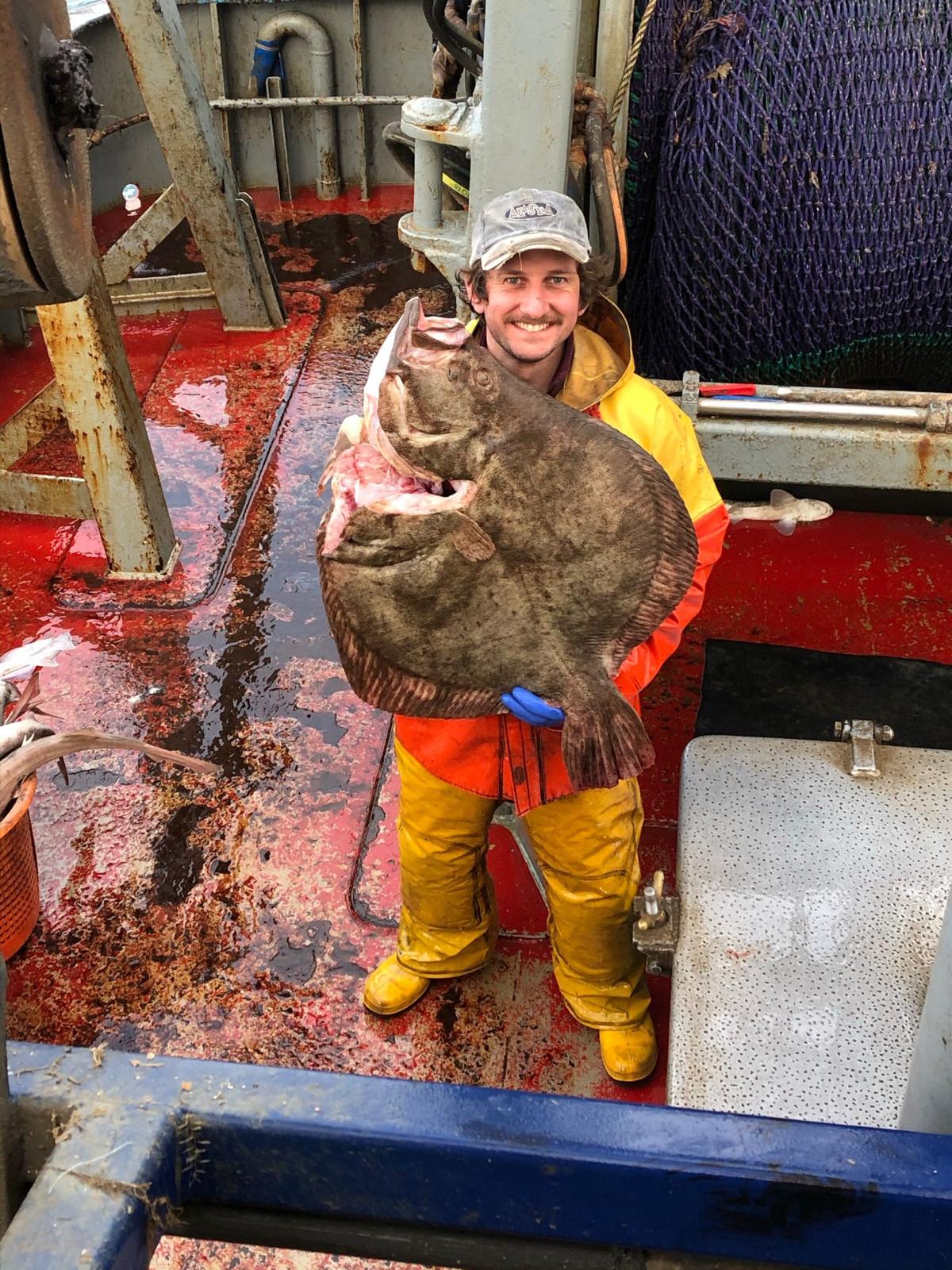 Crew holding a huge turbot — daytime