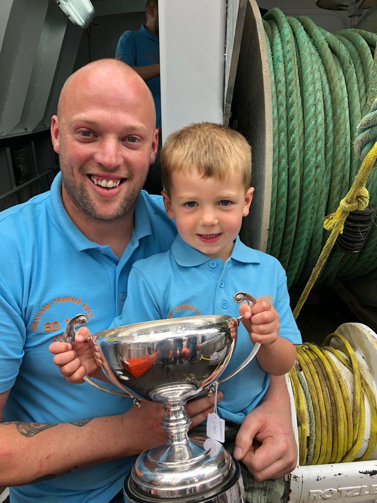 Skipper and son with the race trophy