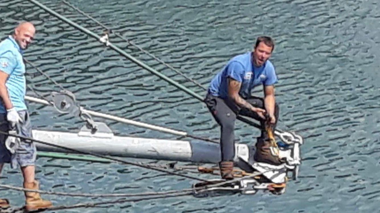 Two crew working on the bowsprit